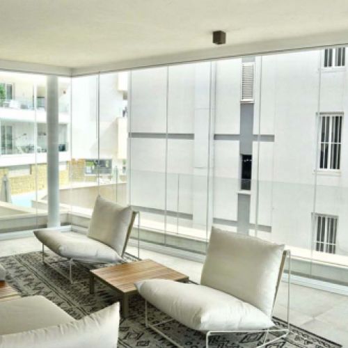 Detalle de cortina de cristal plegada y cerramiento en cristal